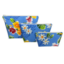 Load image into Gallery viewer, Three makeup bags made of tropical blue fabric with yellow and red hibiscus, monstera leaves, and white pualani flower. Includes large, medium, and small sizes.
