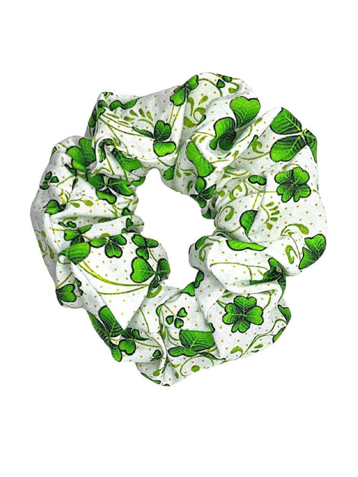 A photo of a cotton scrunchie with a white background and a pattern of clovers in vines with small gold dots.